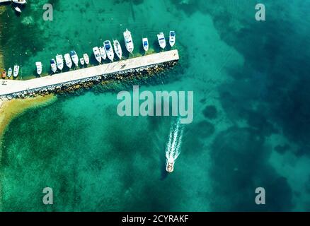 Luftaufnahme von erstaunlichen Booten in Kroatien. Minimalistischer Landschaftshintergrund mit Booten und Meer in Marina Bay. Draufsicht von der Drohne des Hafens mit Yacht, Motorboot und Segelboot. Wunderschöner Hafen Stockfoto