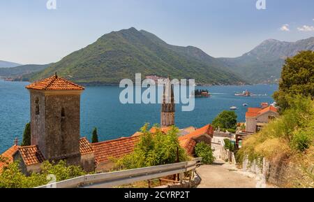 Blick auf Perast, Montenegro mit altem katholischen Kloster im Vordergrund, dem Glockenturm von St. Nikolaus und der Bucht von Kotor mit Inselchen Stockfoto