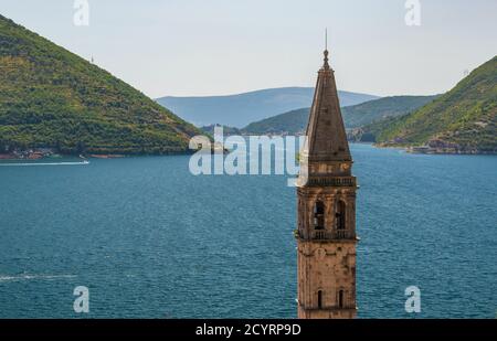 Die Spitze des Glockenturms der St. Nikolaus Kirche in Perast, Montenegro, umrahmt von der Bucht von Kotor See mit Lepetane - Kamenari Fähre in der Ferne Stockfoto