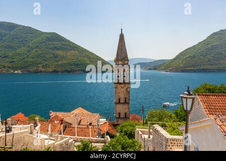 Der Glockenturm der St. Nikolaus Kirche in Perast, Montenegro, eingerahmt von der Bucht von Kotor See mit Kamenari in der Ferne Stockfoto