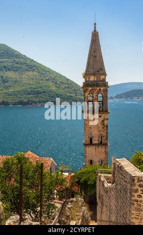 Hohe Ansicht des Glockenturms der St. Nikolaus Kirche in Perast, Montenegro mit Bucht von Kotor See hinter Stockfoto