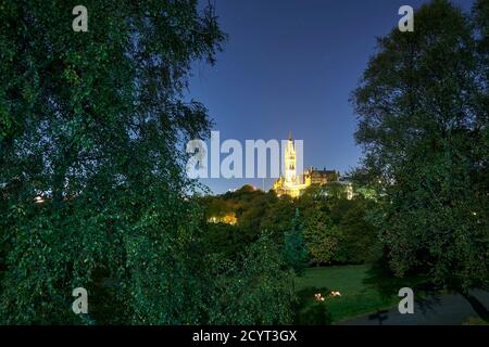 Studenten genießen einen Drink bei Kerzenschein bei Vollmond im Kelvingrove Park mit der Glasgow University in der Ferne. Stockfoto