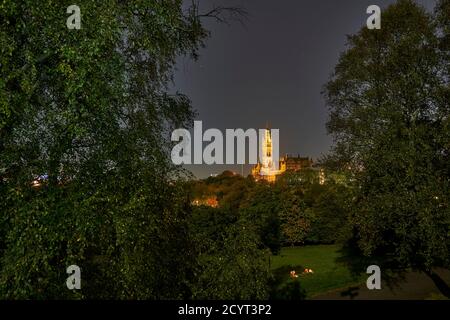 Studenten genießen einen Drink bei Kerzenschein bei Vollmond im Kelvingrove Park mit der Glasgow University in der Ferne. Stockfoto