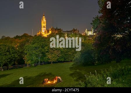 Studenten genießen einen Drink bei Kerzenschein bei Vollmond im Kelvingrove Park mit der Glasgow University in der Ferne. Stockfoto