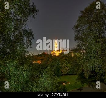 Studenten genießen einen Drink bei Kerzenschein bei Vollmond im Kelvingrove Park mit der Glasgow University in der Ferne. Stockfoto