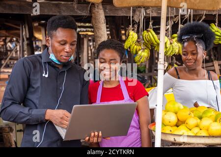 Junger Wirtschaftsagent, der einem Händler etwas auf seinem Laptop zeigt Stockfoto