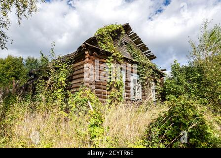 Altes verlassene Holzhaus auf dem Land im Sommer Tag. Region Nowgorod, Russland Stockfoto