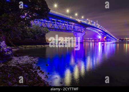 Die Auckland Harbour Bridge, Auckland, Neuseeland, farbenfroh beleuchtet in der Nacht, um Matariki, das Maori-Neujahr zu feiern Stockfoto