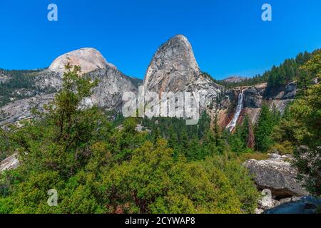 Panorama von Half Dome, Mt Broderick und Liberty Cap mit Nevada Fall Wasserfall auf Merced River vom Mist Trail im Yosemite National Park. Sommer Stockfoto