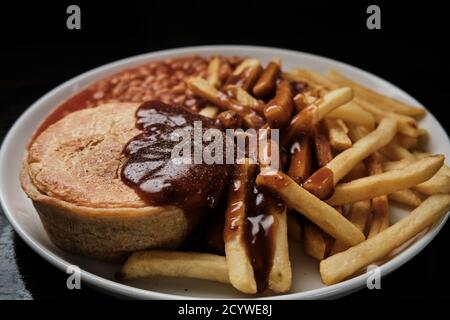 Steak und Kidney Pie, Chips, Bohnen und Soße Stockfoto