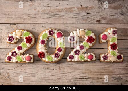 2021 Kuchen auf Holzhintergrund. Konzept für das neue Jahr. Stockfoto