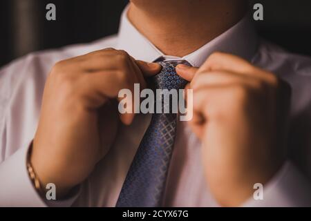 Mann in einem weißen Hemd strafft seine Krawatte Stockfoto