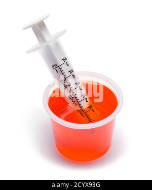 Tasse Orange Medizin mit oraler Spritze. Stockfoto