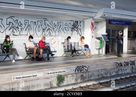 ROM, ITALIEN - OKTOBER 01 2020: Pendler, die Schutzmasken tragen, warten in Rom, Italien, auf einen Zug. Stockfoto