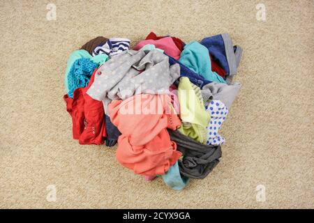 Haufen achtlos verstreuter Kleidung auf dem Boden. Draufsicht. Stockfoto