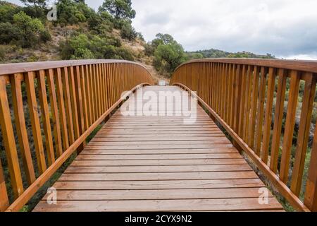 Holzbrücke, am Wasserweg (Acequia) in der Nähe des Guadalmina Canal Trail, Benahavis, Andalusien, Spanien. Stockfoto