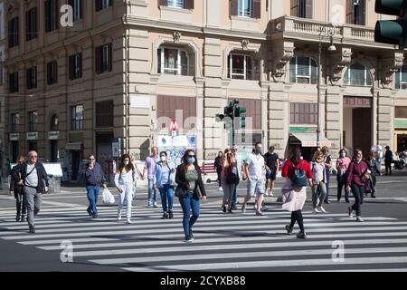 ROM, ITALIEN - OKTOBER 01 2020: Pendler, mit Schutzmaske, überqueren eine Straße in Rom, Italien. Stockfoto
