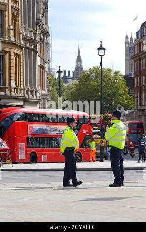 London, England, Großbritannien. Polizeibeamte im Dienst am Trafalgar Square, Blick hinunter Whitehall auf das Parlament Stockfoto