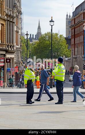 London, England, Großbritannien. Polizeibeamte im Dienst am Trafalgar Square, Blick hinunter Whitehall auf das Parlament Stockfoto