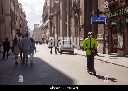 ROM, ITALIEN - OKTOBER 01 2020: In Romes Via del Corso, Italien, fährt ein Mann mit einer schützenden Gesichtsmaske auf einem Elektroroller. Stockfoto