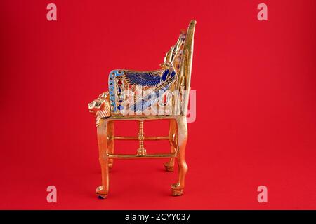 Schöne handgemachte Duplikat von König Pharao Tutanchamun Thron auf rotem Hintergrund - Reise nach Ägypten Konzept. Stockfoto