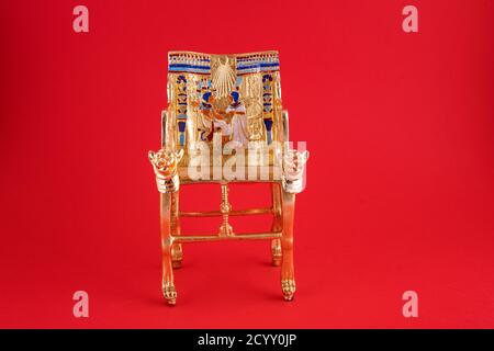 Schöne handgemachte Duplikat von König Pharao Tutanchamun Thron auf rotem Hintergrund - Reise nach Ägypten Konzept. Stockfoto