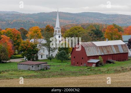 Eine kleine Kirche befindet sich auf einem Bauernhof in der Nähe einer verwitterten Red Barn im Herbst in Vermont. Stockfoto