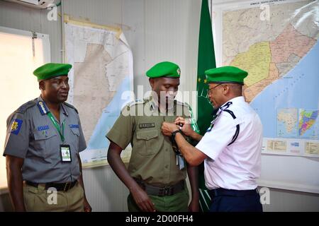 AMISOM-Polizeikommissar, stellvertretender Generalinspektor der Polizei (AIGP), Augustine Magnus Kailie (rechts), stifte eine Medaille auf einen kenianischen Polizeibeamten, der unter der Mission der Afrikanischen Union in Somalia (AMISOM) dient, während einer Medaillenvergabe in Mogadischu, Somalia, am 8. Februar 2020. Stockfoto