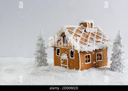 Kreative Winterkomposition mit handgefertigtem Lebkuchenhaus. Wunderschöne Weihnachtskarte. Stockfoto