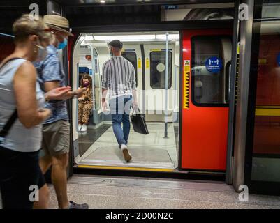 Passagiere, die in einen Londoner U-Bahn-Zug einsteigen. Stockfoto