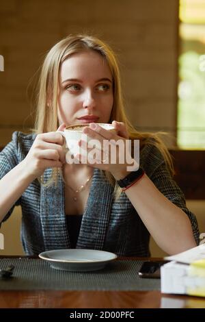 Junge blonde Frau mit einer Tasse Tee, Blick beiseite, träumen Stockfoto