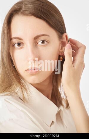 Ernst junge Frau in weißer Bluse Blick auf Kamera auf Weißer Hintergrund Stockfoto