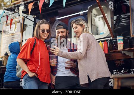 Eine Gruppe von Freunden, die vor dem Food Truck rumhängen Stockfoto