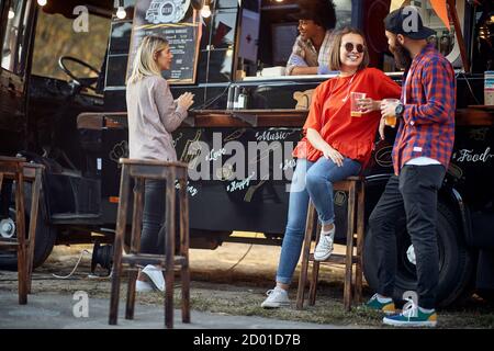 Freunde chillen mit Bier vor dem Foodtruck Stockfoto