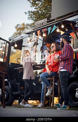 Freunde chillen mit Bier vor dem Foodtruck Stockfoto
