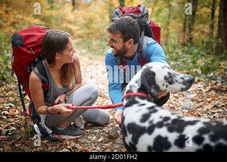 Paare wandern zusammen mit einem Hund; Active Lifestyle Konzept Stockfoto