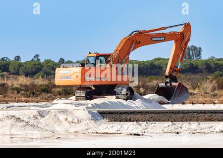 Huelva, Spanien - 1. Oktober 2020: Bagger stapeln Meersalz im Naturschutzgebiet Marismas del Odiel. Die traditionelle Herstellung von Meersalz ist das Salz Stockfoto