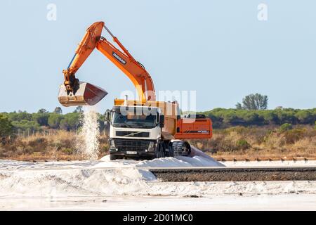 Huelva, Spanien - 1. Oktober 2020: Bagger lädt Salz in einen LKW im Naturschutzgebiet Marismas del Odiel. Traditionelle Meersalzproduktion ist Salz, das Stockfoto