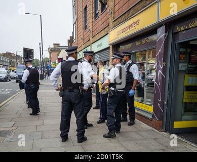 Die Polizei im East End von London, die einen Verdächtigen festnahm. Stockfoto