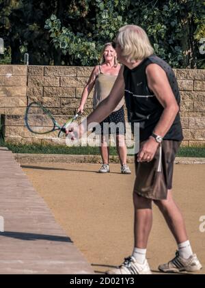 Bukarest/Rumänien - 09.19.2020: Altes Paar spielt Tennis im Park. Selektiv konzentrieren Sie sich auf die Dame im Hintergrund. Stockfoto