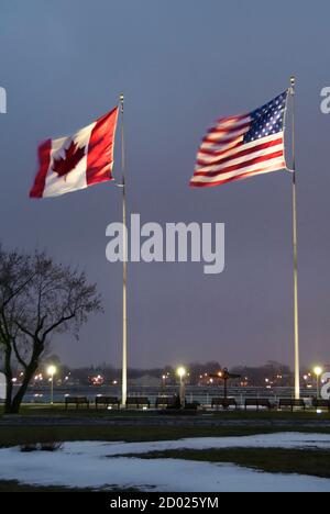 Amerikanische und kanadische Kanada Flaggen fliegen in Port Huron, Michigan, in der Nacht Seite an Seite Stockfoto