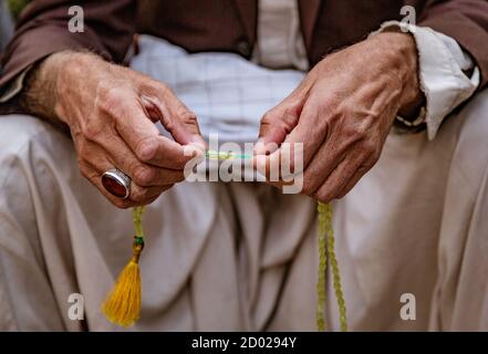Muslimischen Mann benutzt sein Gebet Perlen für das Gebet Stockfoto