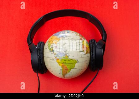 Headset auf Globus isoliert auf dem roten Stockfoto