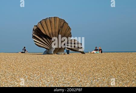 Aldeburgh, Suffolk, England, 9. August 2020, EINE Stahlmuschelskulptur am Strand wird von Strandbesuchern bewundert. Stockfoto