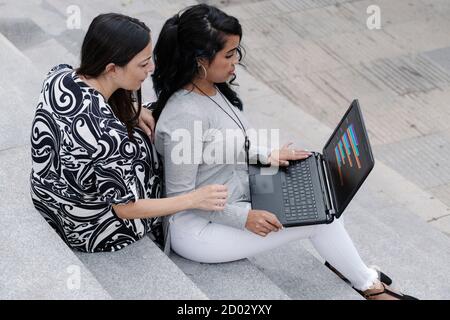 Geschäftsfrauen, die mit einem Laptop im Freien arbeiten Stockfoto