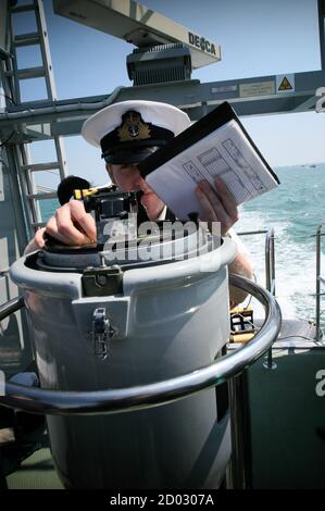 AJAXNETPHOTO. AUF SEE, BRITISCHE HOHEITSGEWÄSSER. - BEARING - ROYAL MARINEOFFIZIER AUF EINEM TRAININGSKILPATROUILLENBOOT NIMMT EINE BEARING MIT EINEM FLIEGENDEN BRÜCKENKOMPASS.FOTO:JONATHAN EASTLAND/AJAX REF:R52706 331 Stockfoto