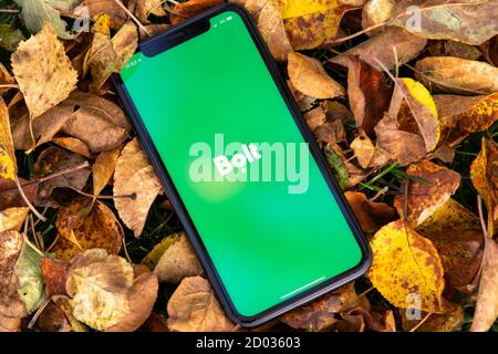 Tallinn / Estland - 28. September 2020: Schwarzes iphone mit Logo der Bolt-Anwendung auf dem Bildschirm. Falled verlässt den Hintergrund. Kann als illustrativ verwendet werden Stockfoto