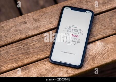 Tallinn / Estland - 28. September 2020: Schwarzes iphone mit Logo der LG ThinQ App auf dem Bildschirm. Holzhintergrund. Kann als Veranschaulichung für Marke verwendet werden Stockfoto