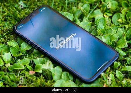 Tallinn / Estland - 28. September 2020: Schwarzes iphone mit Logo der Nachrichtenmedien EuroNews auf dem Bildschirm. Grünes Gras Hintergrund. Kann als Illustration verwendet werden Stockfoto