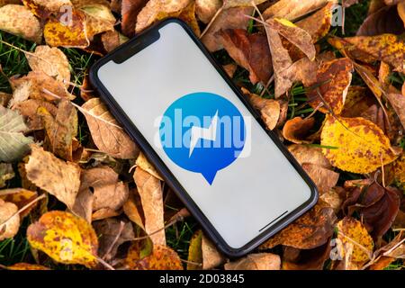 Tallinn / Estland - 28. September 2020: Schwarzes iphone mit Logo des Social Media Facebook Messenger. Falled verlässt den Hintergrund. Kann als Illustration verwendet werden Stockfoto
